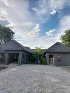 a building with a cobblestone driveway in front of it at Sofitel Inn in Maun