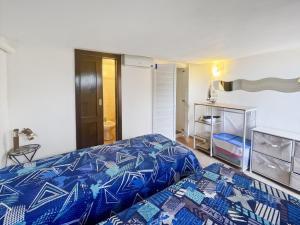 a bedroom with a bed with a blue comforter at Villetta La Risacca - fronte mare - seafront in Costa Paradiso
