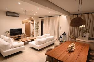 a living room with white furniture and a wooden table at Villa Ino in Myrties