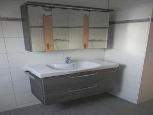 a bathroom with a sink and a mirror at Corinnas Ferienwohnung in Büdingen +14 photos