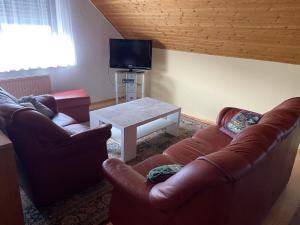 a living room with two leather chairs and a table at Corinnas Ferienwohnung in Büdingen