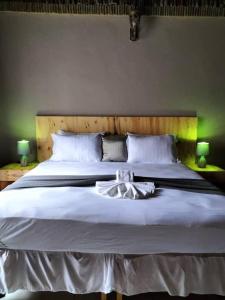 a bedroom with a large white bed with two lamps at Sofitel Inn in Maun +7 photos