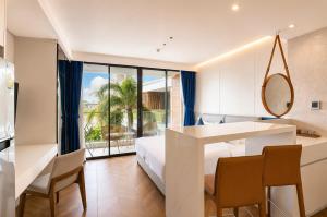 a bedroom with a bed and a table and chairs at Beachfront Luxury Apartment Bangtao Phuket in Bang Tao Beach