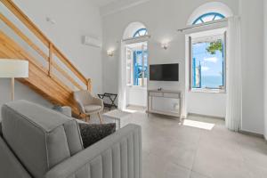 a living room with a couch and a television at Aegean Beachfront Suites in Andros