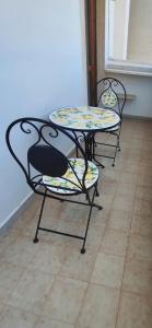 two tables and two chairs with flowers on them at baia verde holiday in Baia Verde