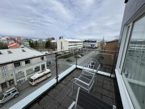 a balcony with chairs and a truck on a city street at Downtown Reykjavík Apartments in Reykjavík