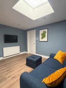 a living room with a blue couch and a television at The Nook County Dublin in Dublin +36 photos