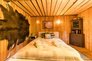 ein Schlafzimmer mit einem Bett in einem Zimmer mit Holzwänden in der Unterkunft Old Silent in Hara