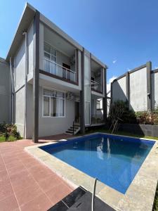 a house with a swimming pool in front of it at Milano Villas Puncak in Puncak