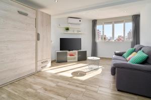 a living room with a couch and a television at Estudio Plazamar Palace in Torre del Mar