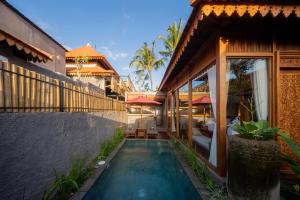 a villa with a swimming pool in front of a house at Bi Bi Bliss Ubud Villa in Ubud