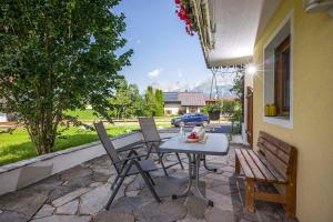 a patio with a table and chairs and a car at Appartements am Römerweg in Oberndorf in Tirol