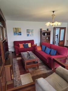 a living room with two red couches and a coffee table at Casa el Bosque in Camargo