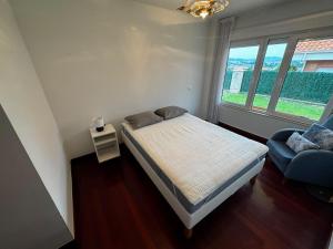 a bedroom with a bed and a couch and a window at Casa el Bosque in Camargo