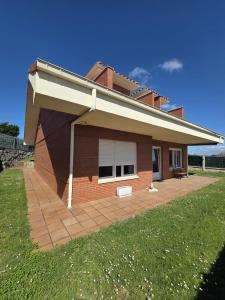 a brick house with a patio in the yard at Casa el Bosque in Camargo
