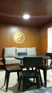 a table and chairs in a room with a couch at La Dominga Tiny House in La Granja