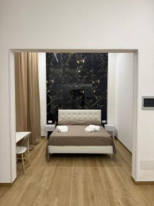 a bedroom with a bed and a black wall at Largo Sicilia B&B in Avola