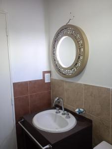 a bathroom with a sink and a mirror on the wall at La Dominga Tiny House in La Granja +5 photos