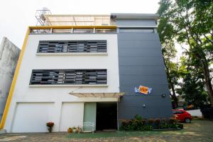 a white building with a sign on it at Behomy J-Home Bandung in Bandung