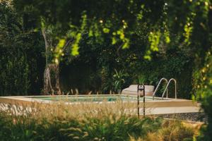 a swimming pool with two faucets in a garden at My Secret Mojo, Private Luxury Retreat Near the Beach in Lefkada