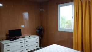 a bedroom with a bed and a dresser with a window at La Dominga Tiny House in La Granja