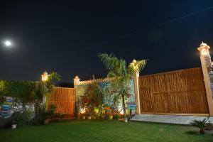 a fence in a yard at night with the moon at The Bagh Village Resort & Spa in Sawāi Mādhopur