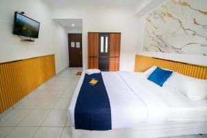 a bedroom with a large bed and a flat screen tv at Behomy J-Home Bandung in Bandung