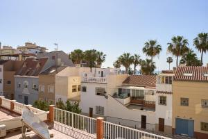 a view of a city with palm trees and buildings at Estudio Plazamar Palace in Torre del Mar