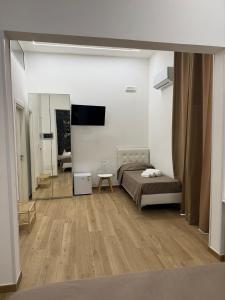 a bedroom with a bed and a mirror in a room at Largo Sicilia B&B in Avola