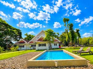 a house with a swimming pool in the yard at Ping Dara Pool Villa Party in Ban San Pa Sak