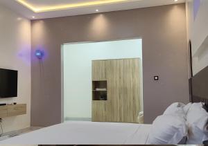 a bedroom with a door in the wall with a television at Appartement de Deux chambres Salon à Ouando - SKYFORCE Bénin in Porto-Novo