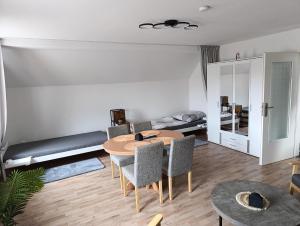 a living room with a table and chairs and a bed at Pferdepension Jäger in Markranstädt