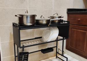 two pots and pans on a shelf in a kitchen at Appartement de Deux chambres Salon à Ouando - SKYFORCE Bénin in Porto-Novo