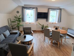 a living room with a couch and a table and chairs at Pferdepension Jäger in Markranstädt