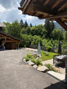 a patio with a table and umbrella and flowers at Chalet La Telier in Montriond
