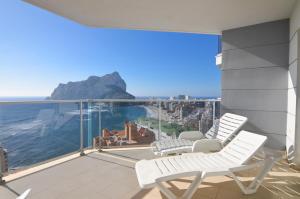 a balcony with white chairs and a view of the ocean at Apartamentos Entremares - Grupo Antonio Perles in Calpe