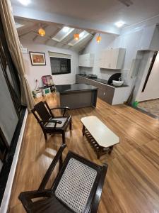 a living room with chairs and a table and a kitchen at Kanakdhara farmhouse in Ujjain +14 photos