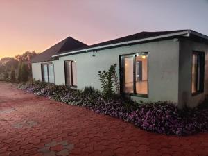 a house with purple flowers in front of it at Kanakdhara farmhouse in Ujjain