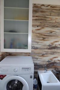 a bathroom with a washing machine and a sink at Vila 26, Lura 2, Gjiri i Lalezit in Ishëm