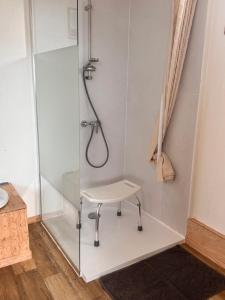 a shower with a chair in a bathroom at Les Cabanes du Cap in Miquelon