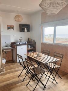 a table and chairs in a kitchen with a window at Les Cabanes du Cap in Miquelon +19 photos