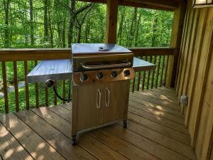 a grill sitting on a porch on a deck at Treehouse by the Creek in Walland +13 photos