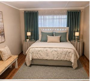 a bedroom with a large bed with green curtains at The Olive Branch - Abbotsford in Dorchester Heights 