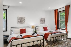 two beds in a bedroom with white walls and windows at Cozy 2BR,1BA Retreat for 6 with Free Parking in Philly in Philadelphia