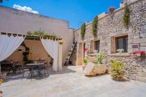 a patio with a table and chairs and a stone wall at Salento Ada's House in Melendugno