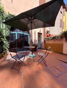 a table and two chairs and an umbrella on a patio at Dimora della Ghiara in Ferrara