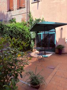 a patio with a table and an umbrella at Dimora della Ghiara in Ferrara +17 photos