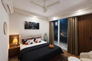 a bedroom with a large bed and a balcony at Cozy Corner in Greater Noida