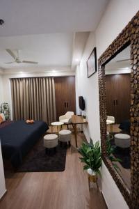 a bedroom with a bed and a mirror and a table at Cozy Corner in Greater Noida