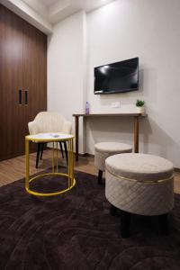 a room with a table and two chairs and a tv at Cozy Corner in Greater Noida